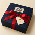 The Blind Date mystery box: a navy gift box with a cream Feline Preferred patch, a red satin bow and a tag with a gold question mark